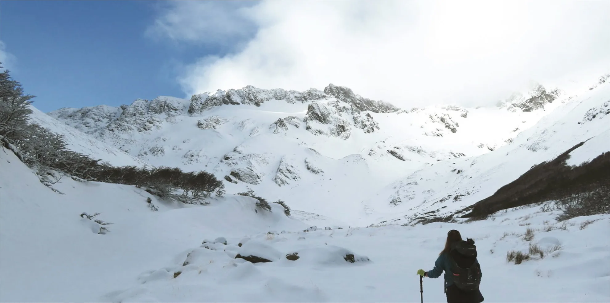 Caminante ascendiendo por un valle nevado de la Sierra Alvear