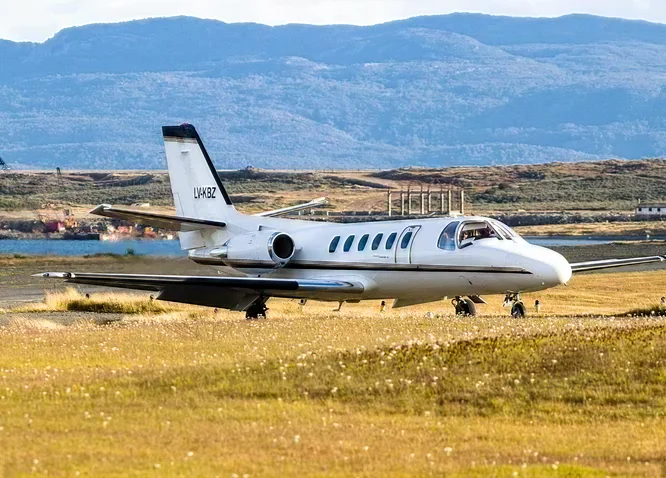 Avión privado en la pista con la montaña de fondo